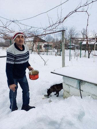 Dumitru feeds his dog outside